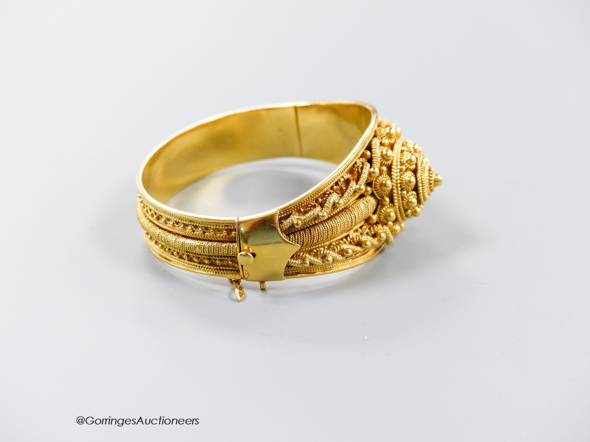 A 20th century Victorian style yellow metal (stamped 19k) cannetile work hinged bracelet, interior diameter 57mm, 60.1 grams.